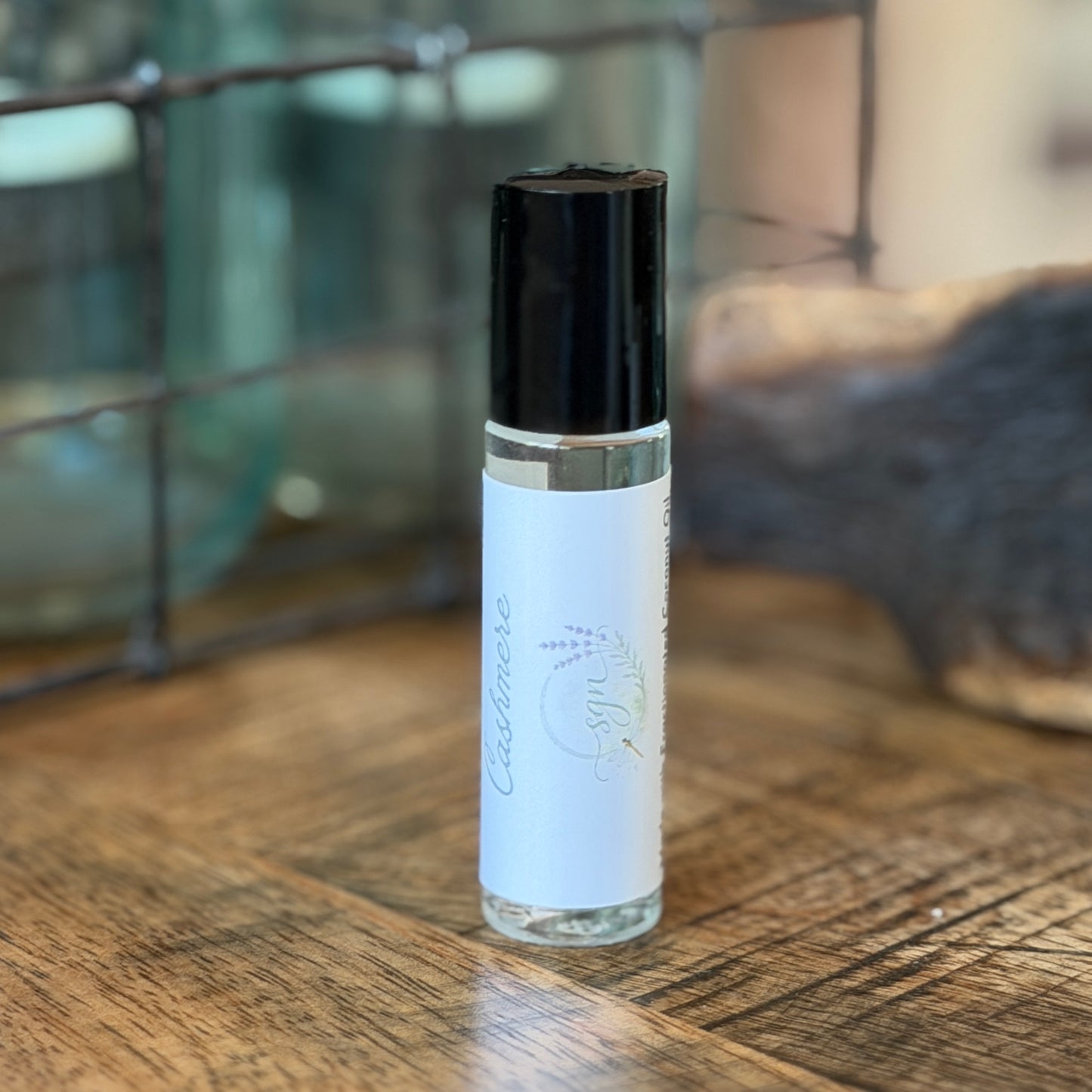 Roll-on bottle with white label and black cap on a wooden surface
