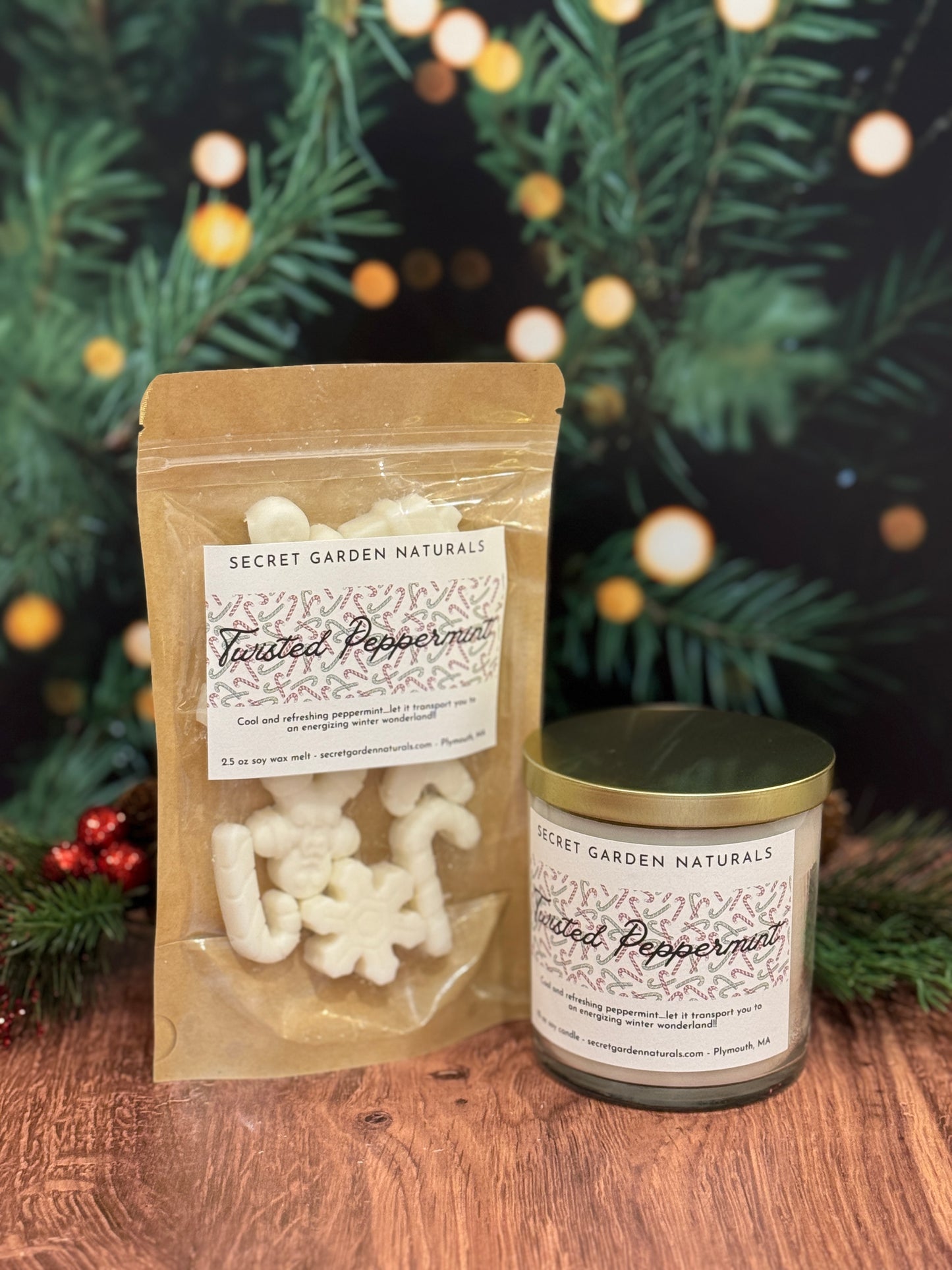 Secret Garden Naturals Twisted Peppermints packaging with a candle on a wooden surface with Christmas decorations.