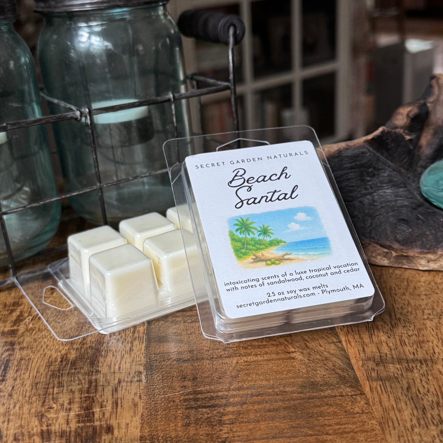 Packaged wax melts with a 'Beach Santal' label on a wooden surface.