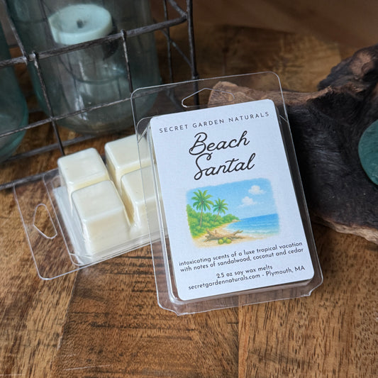 Beach Santal soy wax melts with the picture of a beach, sitting on a wooden table.