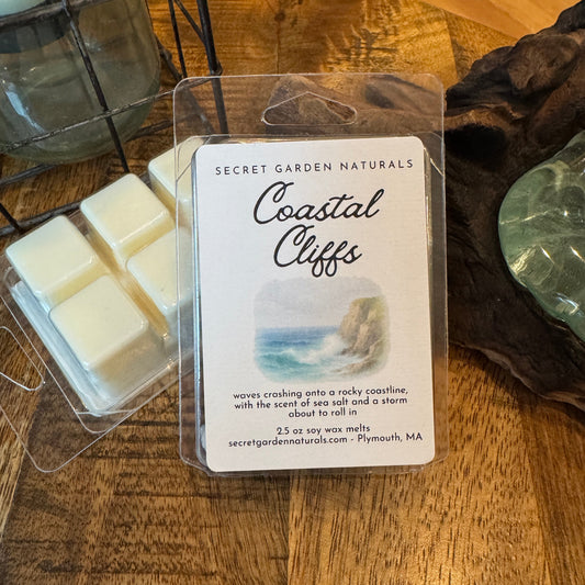 Packaged Coastal Cliffs wax melts with a label on a wooden surface