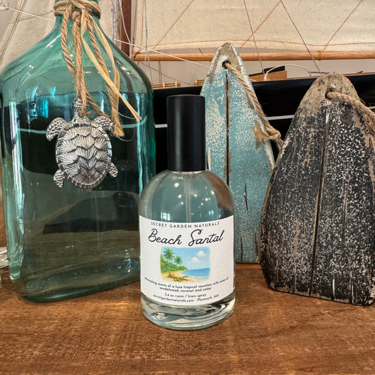 Bottle of Beach Santal room spray on a wooden shelf with nautical decor