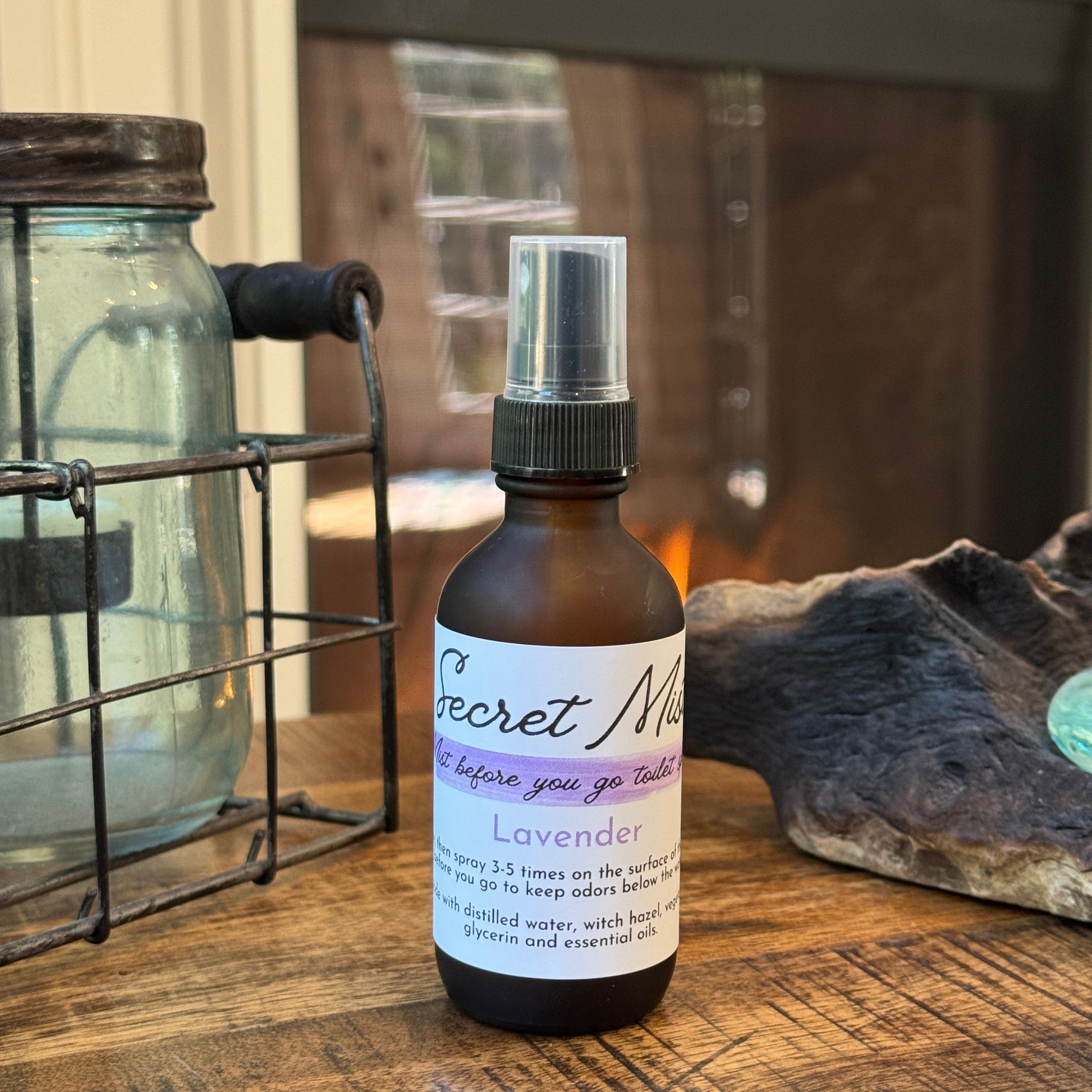 Bottle of 'Secret Mist' lavender toilet spray on a wooden surface.