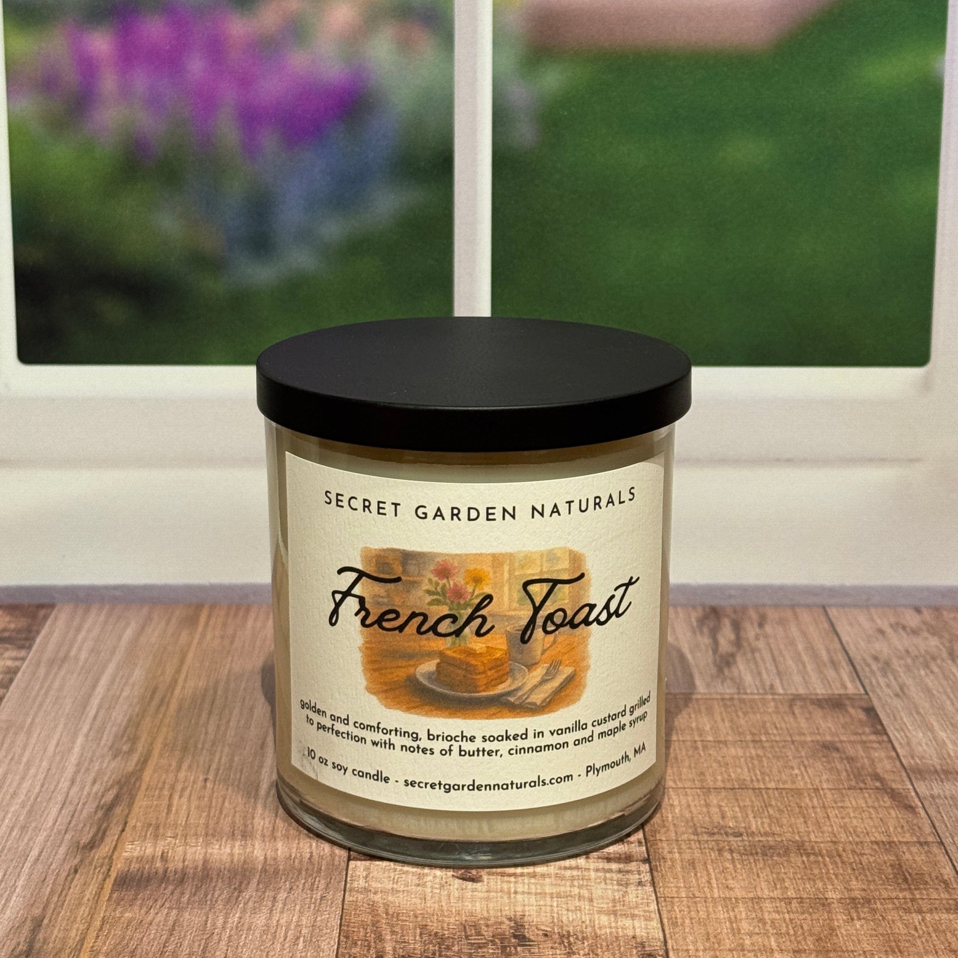 Candle labeled 'French Toast' on a wooden surface with a blurred background